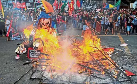  ??  ?? Flames of fury: Protesters burning an effigy with a skull face during a National Day of Protest outside the presidenti­al palace in metro Manila. — Reuters
