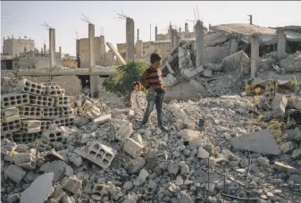  ?? Alice Martins / Washington Post ?? Children walk along rubble in Ain Issa, Syria, about 30 miles north of Raqqa, the extremists’ capital. A larger U.S. presence is expected to accelerate the fight against the Islamic State.