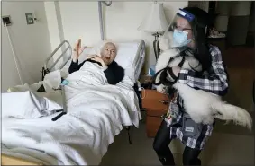  ?? SETH WENIG — THE ASSOCIATED PRESS ?? Jeff Philipson, 80, exclaims as therapeuti­c activities staff member Kate DelPizzo arrives for a visit with Zeus, a bichon frise, at The Hebrew Home at Riverdale in New York.