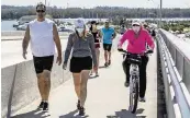  ?? AL DIAZ adiaz@miamiheral­d.com ?? People venture out to walk, jog and bike along the Rickenback­er Causeway. Walking can reduce risk for high blood pressure, heart disease, diabetes and depression, and it can help control weight and improve sleep.