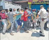  ?? PTI ?? Police try to control the crowd as people stand in a queue, flouting n social distancing measures, to buy alcohol in Delhi on Tuesday.