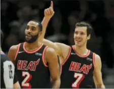  ?? PAUL BEATY — THE ASSOCIATED PRESS ?? Miami’s Goran Dragic (7) and Wayne Ellington (2) celebrate after Dragic made a basket Sunday against Chicago.