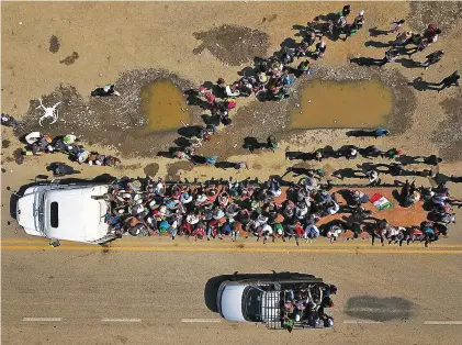  ?? RODRIGO ABD/ASSOCIATED PRESS ?? Migrants climb on the trailer of a truck as others wait in a line for a ride on the road that connects Tapanatepe­c with Niltepec, Mexico, as a caravan of Central Americans continues its slow march Monday toward the U.S. border.