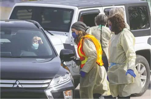  ?? Mike Hensen / Postmedia news ?? People are screened in their cars for COVID-19 at London’s first assessment centre at Oakridge Arena on March 16. Their informatio­n was taken down and if necessary they were asked to park and go for further screening.