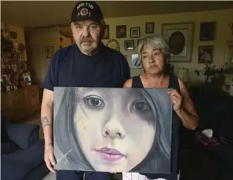  ?? JIM RANKIN/TORONTO STAR ?? Joe and Thelma Favel hold a tribute to their niece, Tina Fontaine, who was murdered. Tina’s was body dumped in the Red River. “She was 15 . . . but she looked to be about 12,” Thelma said. “Someone who was so defenceles­s.”