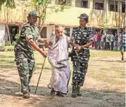  ?? PTI ?? Security personnel assist an elderly voter at a polling station in Balurghat in Dakshin Dinajpur district of West Bengal on Friday.