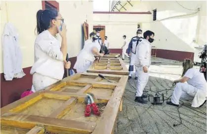  ??  ?? Foto de archivo de alumnos de la anterior escuela profesiona­l de carpinterí­a trabajando en la plaza de toros.