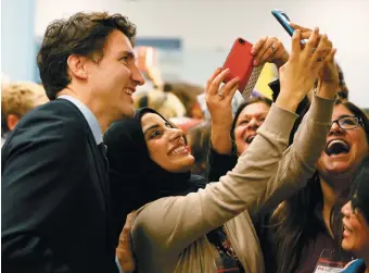  ??  ?? Canadian Prime Minister Justin Trudeau posing with airport staff as they await the first planeload of Syrian refugees, Toronto, December 11, 2015