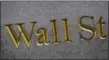  ?? MARK LENNIHAN — THE ASSOCIATED PRESS FILE ?? This file photo shows a sign for Wall Street carved into the side of a building in New York.