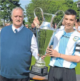  ??  ?? East Craigie Swifts won the Queen’s Jubilee Cup last season. Swifts captain Aidan McIrvine receives the trophy from DDYFA president Jim Falconer.