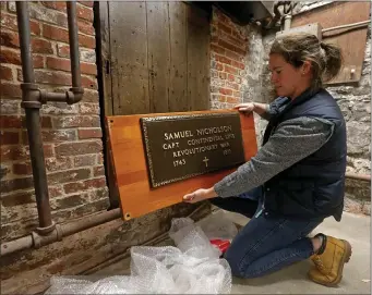  ?? STUART CAHILL — BOSTON HERALD ?? Lauren Knollmeyer holds the Samuel Nicholson plaque, that will be mounted as the Old North Church rehabilita­tes the doors to it’s crypts.