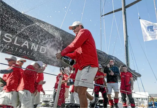  ?? HEATH HOLDEN/GETTY IMAGES ?? Crew members of Wild Oats XI celebrate at Constituti­on Dock after taking their ninth line honours in the 2018 Sydney to Hobart yacht race yesterday.