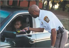  ??  ?? Charles County Sheriff Troy Berry hands out a safe driving flier at La Plata High School Wednesday morning, as part of the “We Care” safe driving campaign.