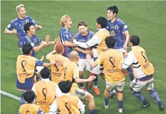  ?? — AFP photo ?? Japan’s Ritsu Doan (centre) celebrates with teammates after scoring in the match against Germany.