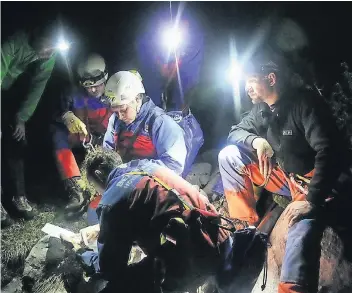  ?? FOTO: DPA ?? Einsatzkrä­fte der Bergwacht beraten das weitere Vorgehen am Untersberg beim Eingang in die Riesending-Schachthöh­le. Der verletzte Forscher kann frühestens in einigen Tagen geborgen werden.