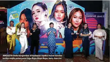  ?? FOTO AZIAH AZMEE ?? ANGGOTA Dolla bergambar di hadapan replika mural mereka ketika majlis pelancaran lagu Raya Raya Raya, baru-baru ini.