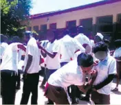  ?? ?? Matric learners help one another write messages on their school uniforms after finishing their last exam paper.