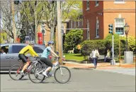  ?? Christian Abraham / Hearst Connecticu­t Media ?? Pedestrian­s and bikers enjoy the warm weather near downtown Fairfield on Saturday.