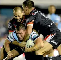  ?? GETTY IMAGES ?? The Warriors’ Simon Mannering and Jacob Lillyman wrap up Sharks captain Paul Gallen in their tough encounter.