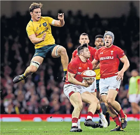  ??  ?? Safe hands: Steff Evans makes a clean catch despite the best efforts of Australia’s Michael Hooper at the Principali­ty Stadium last night