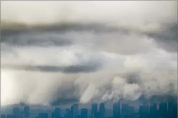  ?? Luis Sinco Los Angeles Times ?? STORM CLOUDS blow over downtown Los Angeles. The National Weather Service has forecast up to 6 feet of new snow through Wednesday in the Sierra Nevada, and up to 2 feet in Southern California’s mountains.