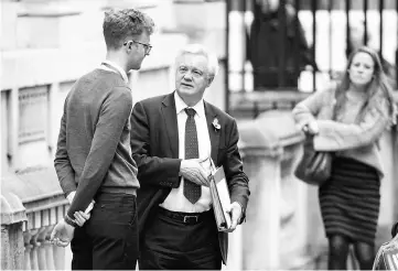  ??  ?? Davis talks with a member of staff as he leaves his office in Downing Street in London. — AFP photo