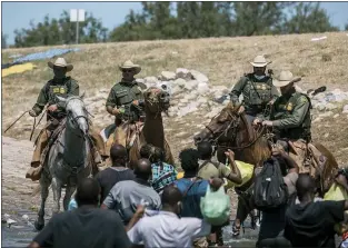  ?? FELIX MARQUEZ — THE ASSOCIATED PRESS ?? U.S. Customs and Border Protection mounted officers attempt to contain migrants as they cross the Rio Grande from Ciudad Acuña, Mexico, into Del Rio, Texas, Sunday, Sept. 19, 2021. Thousands of Haitian migrants have been arriving to Del Rio, Texas, as authoritie­s attempt to close the border to stop the flow of migrants.