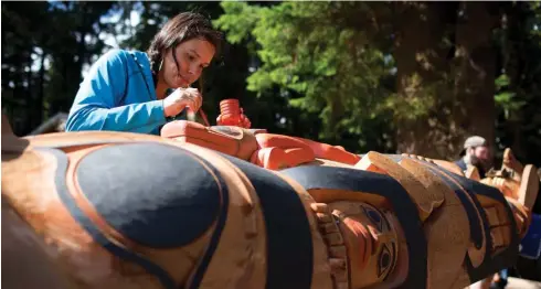  ??  ?? Above: Jusquan Bedard adds final touches to the Gwaii Haanas legacy totem pole before it is raised in Windy Bay, Haida Gwaii, B.C., on August 15, 2013.