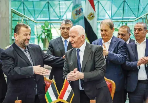  ?? Foto: dpa ?? Saleh al-Aruri, Vizechef des Hamas-Politbüros, und Assam al-Ahmad, Leiter der Fatah-Delegation, schütteln sich die Hände.