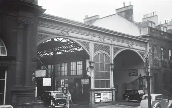  ?? G E S Parker/Kiddermins­ter Railway Museum ?? The main road entrance to Edinburgh’s Princes Street station was on Rutland Street, immediatel­y flanking a north-west facing wing of the Caledonian Hotel, its entrance being at the corner of Lothian Road and Rutland Street, and with Shandwick Place and Princes Street just across the road. This scene was recorded on 5 October 1963 as Austin ‘FX3’ taxis come and go, the station concourse and platforms being beyond the arches, while a Triumph ‘Razor-edge’ Renown is parked in the street. A visit here today will reveal the same frontage alongside the hotel, but the girders of the roof structure are all gone, as indeed are the advertised excursions.