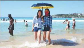  ?? DON ARNOLD / GETTY IMAGES ?? Young travelers from Beijing pose in the surf at Bondi Beach in Sydney, Australia, last year. The country is a popular destinatio­n with Chinese tourists.