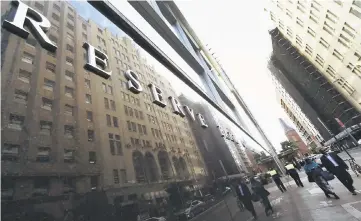  ??  ?? People walk past the Reserve Bank of Australia building in the central business district of Sydney on July 4. Asian share markets inched back into the black yesterday as investors wagered the latest flare-up of tensions on the Korean peninsula would...