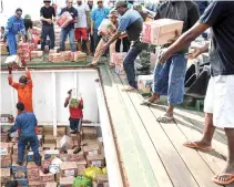  ?? REUTERS ?? WORKERS unload aid for earthquake and tsunami victims at Pantoloan port in Palu, Central Sulawesi, Indonesia in this Oct. 3 photo taken by Antara Foto.