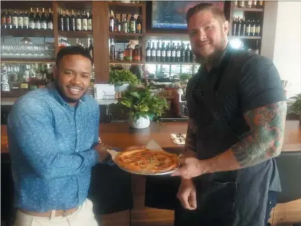  ?? GARY PULEO — DIGITAL FIRST MEDIA ?? North Italia manager Desmond Carr, left, and chef Travis Turner show off one of the restaurant’s most popular items, Margherita pizza.