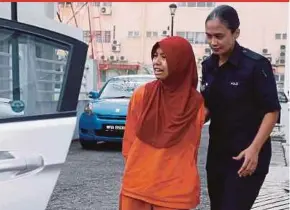  ?? PIC BY AIZUDDIN SAAD ?? Nor Solihah Abdul Majid being led out of the court complex in Kajang on May 15.