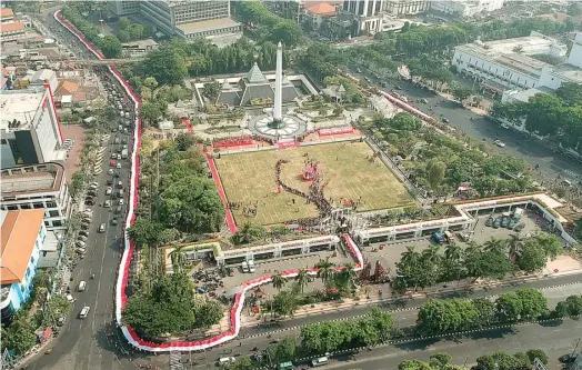  ?? PUGUH SUJIATMIKO/JAWA POS ?? BANGKITKAN NASIONALIS­ME: Ribuan siswa mengarak bendera Merah Putih hingga memasuki kompleks Tugu Pahlawan. Mereka juga mengenakan pakaian adat dari seluruh Indonesia.