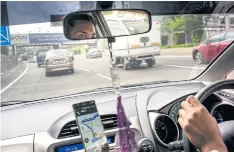  ??  ?? A Grab taxi driver navigates a road in Kuala Lumpur.