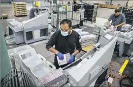  ?? Robert Gauthier Los Angeles Times ?? L.A. COUNTY poll worker Chris Torres processes mail-in ballots at a facility in the city of Industry. Some 13,800 ballots are still left to be counted, officials said.