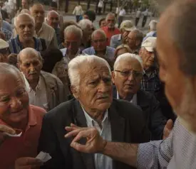  ?? AP ?? GREEKDRAMA Abank employee orders pensioners to line up in numbered order as banks in Athens, Greece, reopen on Wednesday to help desperate pensioners cash retirement checks up to $134 each only.