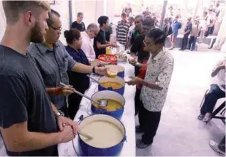  ?? ZULKIFLI ERSAL/THESUN ?? Volunteers serving the evening patrons at Pit Stop Community Cafe.