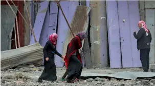  ?? — AP ?? Civilians walk amid the rubbles wafter fighting between Iraqi security forces and Daesh in the eastern side of Mosul.