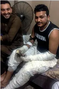  ?? AFP ?? NEW LEASE OF LIFE: Plane crash survivor Mohammed Zubair sitting with a relative at his home in Karachi after being discharged from hospital. —