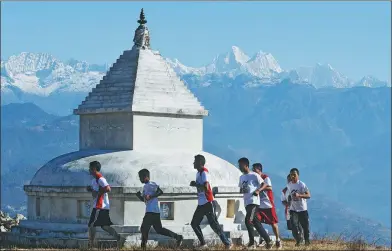  ?? PRAKASH MATHEMA / AGENCE FRANCE-PRESSE ?? Nepali Buddhist monks run during a training session in Sindhukot village, about 80 kilometers northeast of Kathmandu, on Feb 15.