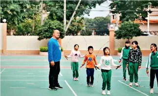  ??  ?? Lai Xuanzhi y sus alumnos en la práctica del salto a la soga.