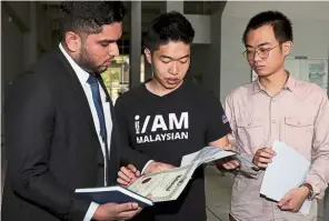  ??  ?? Big relief: Wong (centre) and Kon with their legal representa­tive Asheeq Ali after getting their degree certificat­e.