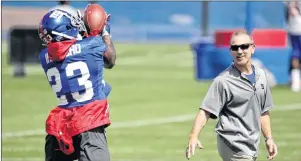  ?? ap photo ?? New York Giants defensive coordinato­r Steve Spagnuolo, right, looks on as defensive back Duke Ihenacho (23) makes a catch during NFL practice Wednesday in East Rutherford, N.J.