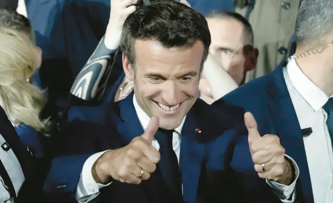  ?? LEWIS JOLY/AP ?? French President Emmanuel Macron gives a thumbs-up Sunday in Paris after hearing reports of his reelection. He received just over 58% of the vote, compared with just under 42% for challenger Marine Le Pen.