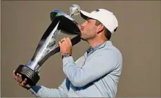  ?? Alastair Grant / Associated Press ?? Charles Schwartzel of South Africa kisses the trophy after he won the inaugural LIV Golf Invitation­al on Saturday.