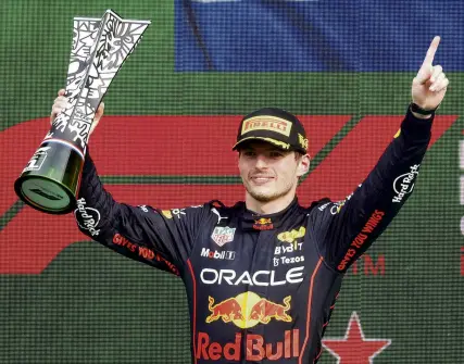  ?? ?? Dutch treat . . . Red Bull driver Max Verstappen, of the Netherland­s, celebrates on the podium with the trophy after winning the Dutch Grand Prix in Zandvoort yesterday. Right: A sea of orange supports Verstappen.