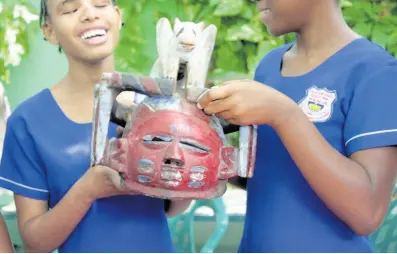  ?? PHOTOS BY AMITABH SHARMA ?? A touch in time - Toshtica Sang (left) and Nicola Anderson get a feel of this African mask during the Touch Tour at National Museum of Jamaica.